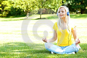 Blonde Woman with Headphone Meditating Outdoor