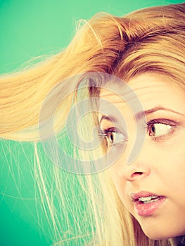 Blonde woman holding her hair ends