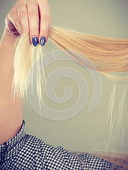 Blonde woman holding her hair ends