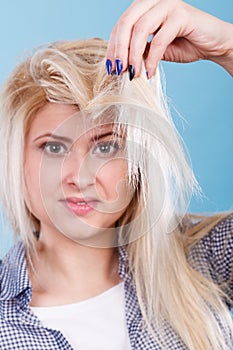 Blonde woman holding her hair ends