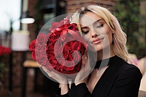 Blonde woman holding red roses close up, valentines day