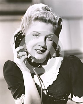 Blonde woman holding telephone receiver