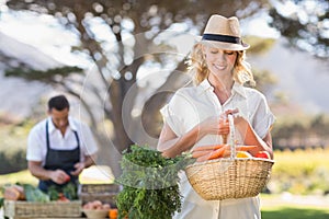 Blonde woman holding a vegetables basket
