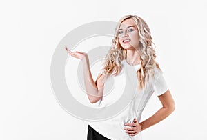 Blonde woman holds an imaginary object in a hand on a white background. Free space for advertising of your product.