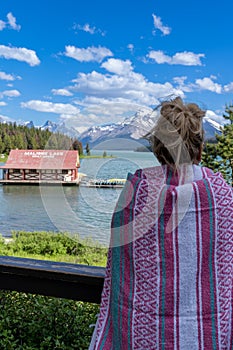 Blonde woman holds up a pink blanket while enjoying the view of Maligne Lake in Jasper National Park Alberta Canada
