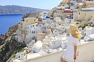 Blonde woman looking at cityscape of Oia village in Santorini island