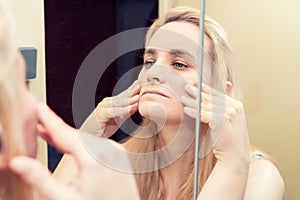 Blonde woman looking at her reflection