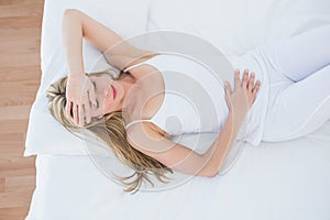 Blonde woman lying suffering from stomach pain