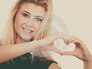 Blonde woman making heart symbol with hands