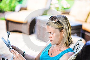 Blonde Woman Outdoors Reading Newspaper