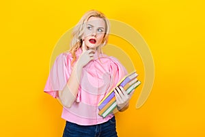 Blonde woman in pink blouse with pile of books