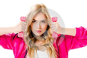 Blonde woman in pink clothes holding dumbbells