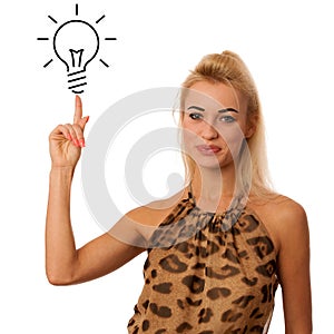 blonde woman pointing to light bulb isolated over white background gesturing new idea