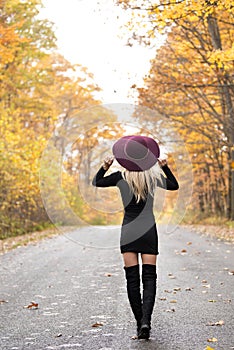 blonde woman poses on country lane in fall