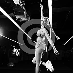 Blonde woman posing with gymnastic rings