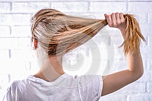Blonde woman pulls her flowing hair to the side