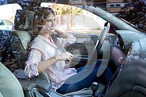 Blonde woman putting the seatbelt before driving