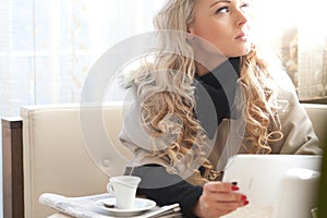 Blonde woman reading on a tablet
