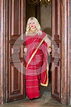 Blonde woman in red dress stands in doorway photo