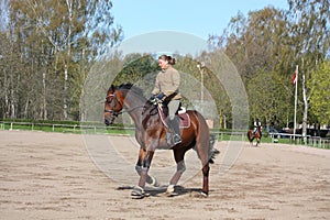 Blonde woman riding bay horse