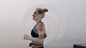 Blonde woman running exercising enjoying beautiful seaside morning healthy caucasian female runner active fitness