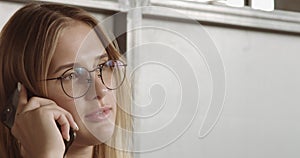 Blonde woman`s portrait talking on mobile smartphone closep