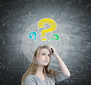 Blonde woman scratching head, question marks