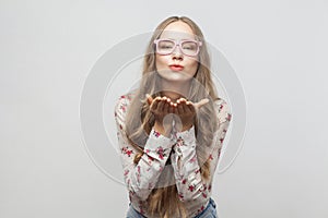 Blonde woman send air kiss at camera with love.