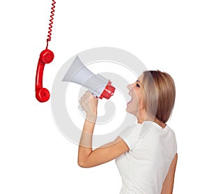Blonde woman shouting through a phone hanging with a megaphone