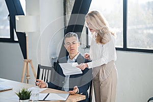 Blonde woman showing na document to her boss