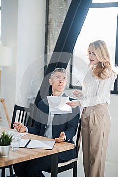Blonde woman showing na document to her boss