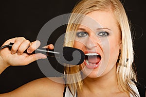 Blonde woman singing to microphone