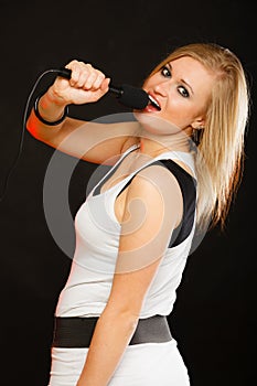 Blonde woman singing to microphone