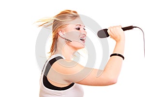 Blonde woman singing to microphone, profile view