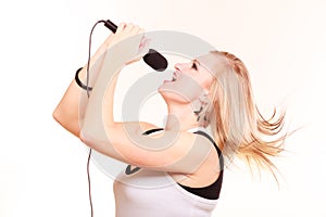 Blonde woman singing to microphone, profile view