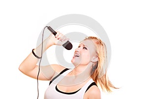 Blonde woman singing to microphone, profile view