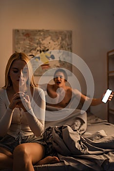 blonde woman sitting on bed next