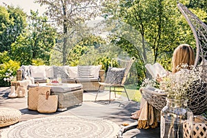 Blonde woman sitting on the terrace of a summer retreat reading