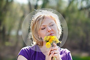 Blonde woman smell dandelion outdoor