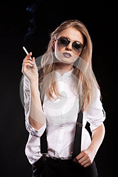 Blonde woman smoking on black background