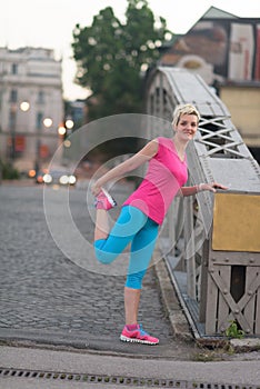 Blonde woman stretching before morning jogging