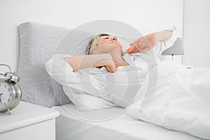 Blonde woman stretching and waking up