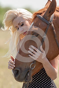 Blonde woman stroking gelding