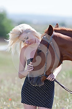 Blonde woman stroking horse