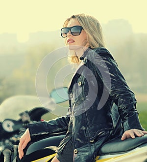 Blonde woman in sunglasses on a sports motorcycle