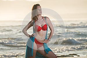 Blonde woman swimming in the ocean with a red bikini