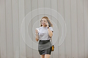 Blonde woman talking to her phone while drinking coffee