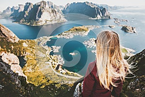Blonde woman on the top of Reinebringen mountain fjord aerial view