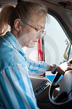 Blonde woman truck driver inside the cab