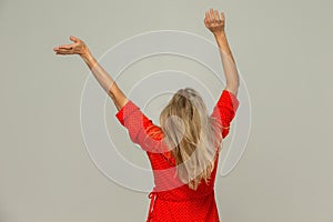 Blonde woman turned her back to the camera and waves her arms